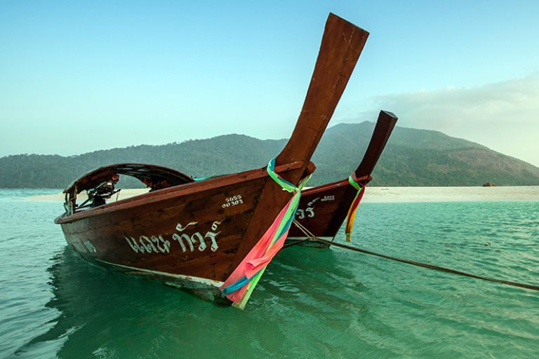 Long boats moored up in sea in Thailand bay